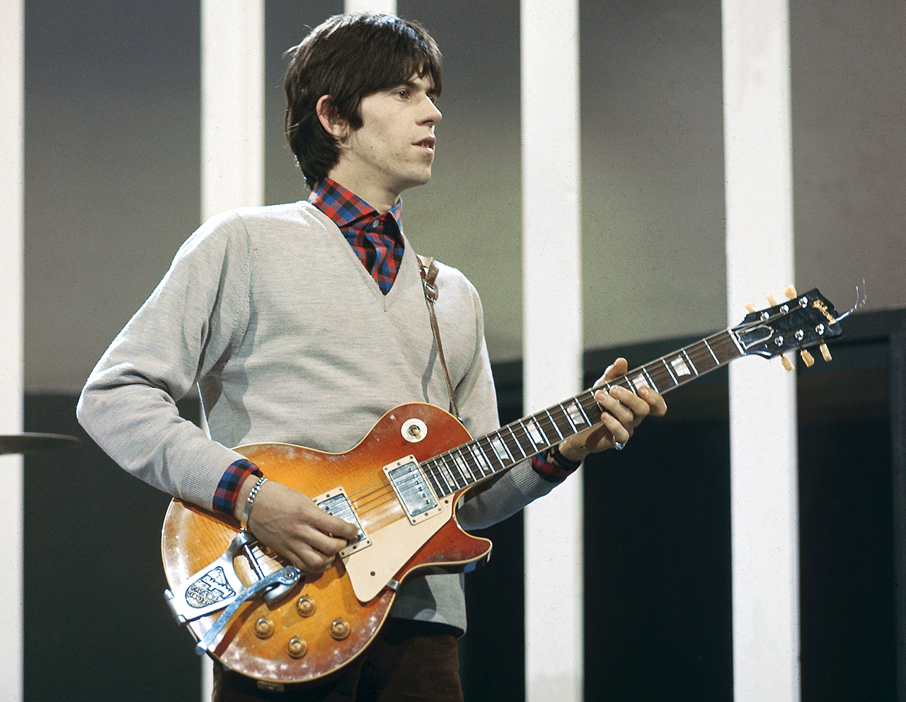 Keith Richards of rock group The Rolling Stones plays a Gibson Les Paul guitar with Bigsby Vibrato on the set of the ABC Television pop music television show Thank Your Lucky Stars in 1965.