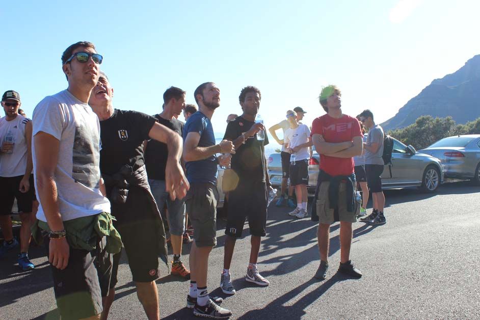 The riders and staff look up at the mountain ahead of the hike