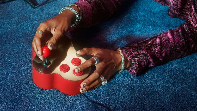 Hands of person wearing rings playing video games