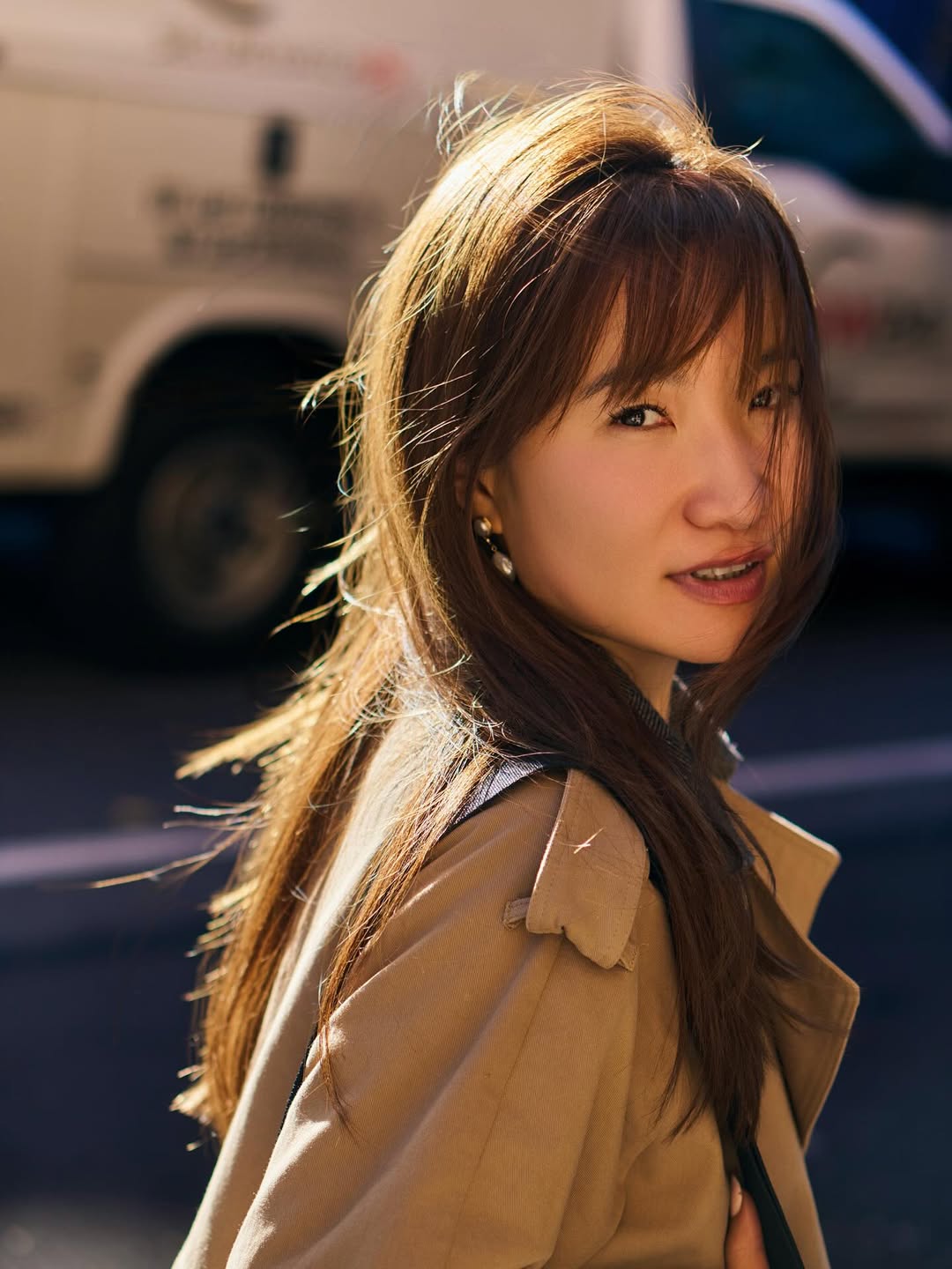 a headshot of a woman with dark hair wearing a beige jacket