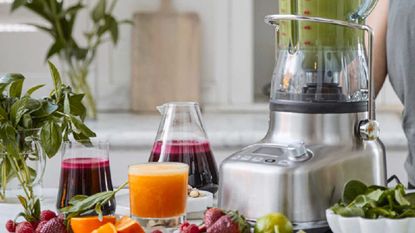 How to make juice in a blender: Breville The Bluicer on a countertop with juice and ingredients around it
