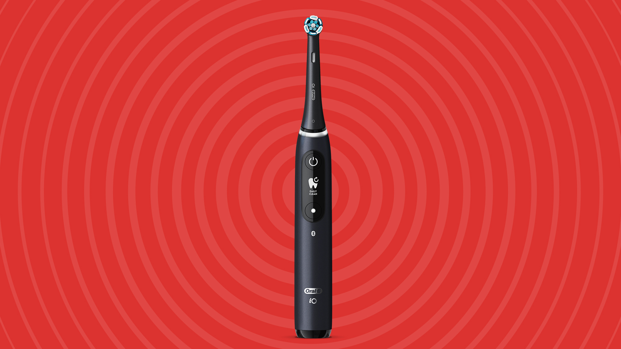 A black Oral-B iO 7 electric toothbrush on a red background