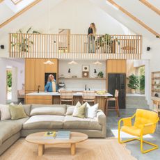 interior of self-build coastal house in cornwall featuring an open-plan living space with a kitchen, dining and seating area, and a mezzanine above