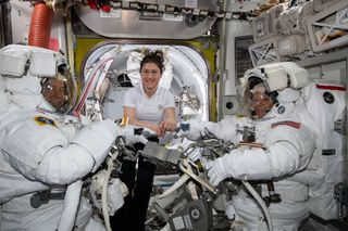 NASA astronaut Christina Koch helps colleagues Nick Hague and Anne McClain suit up for a spacewalk on March 22, 2019.