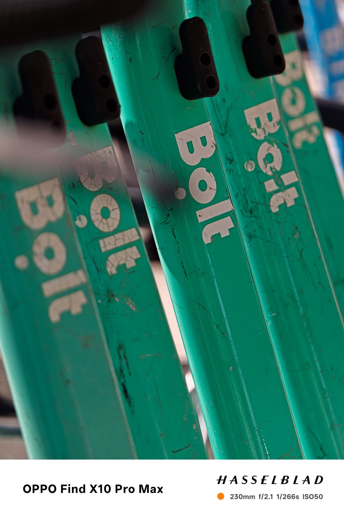 Close-up of several green Bolt rental scooters with shallow depth of field.