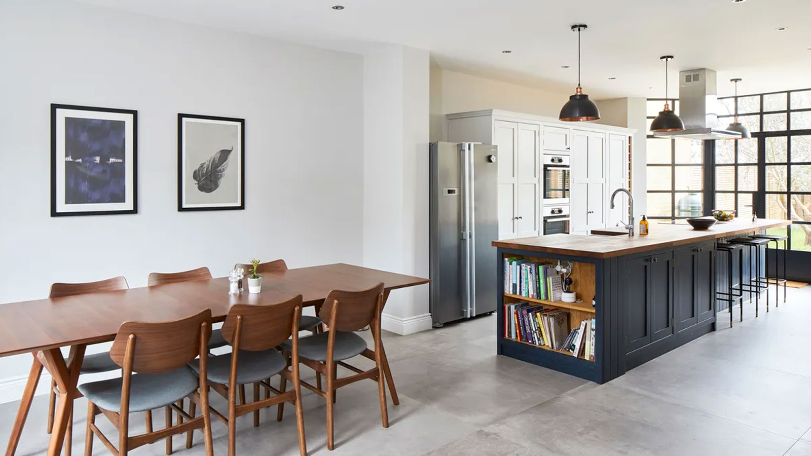 Contemporary kitchen diner with white walls, island and wooden dining table and chairs