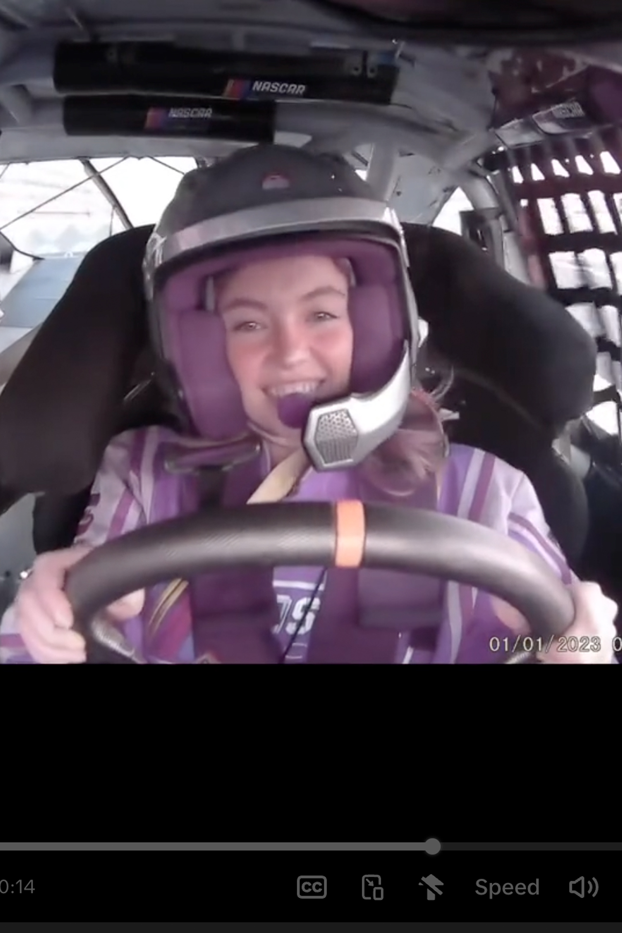 Se captura a Sydney Sweeney agarrando el volante, mostrando esa sonrisa de estrella de cine y conduciendo vueltas como un NASCAR natural.