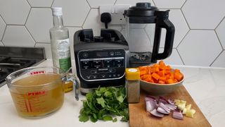 The Ninja Foodi Blender & Soup Maker HB150UK with an array of ingredient ready to make soup