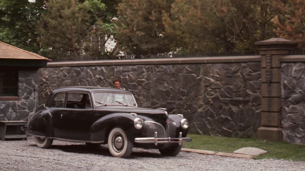 A black Lincoln Continental in front of a stone wall in The Godfather