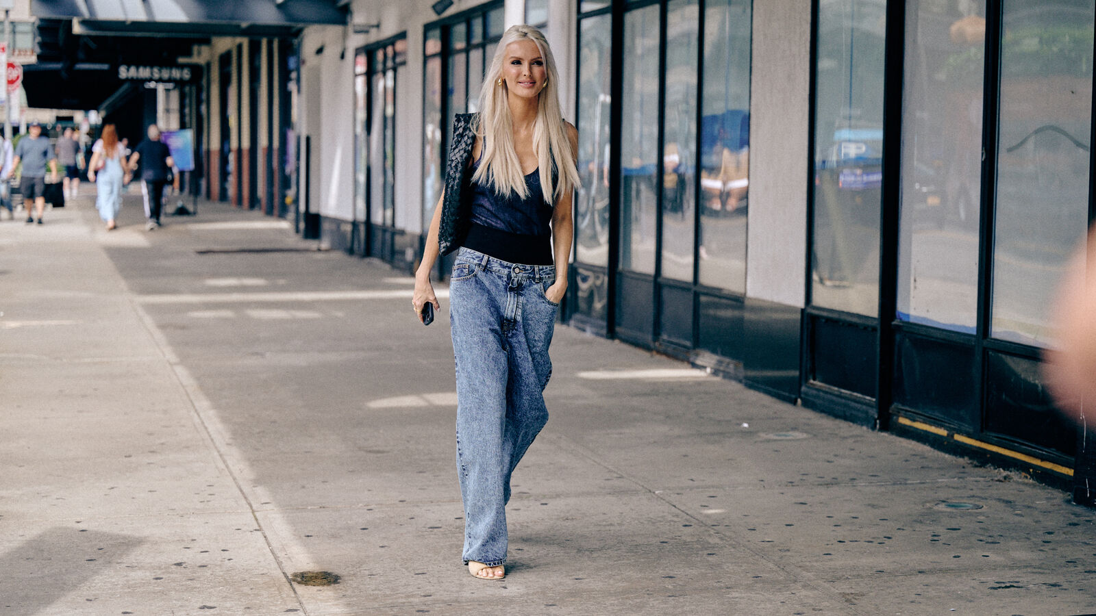 woman wearing jeans and sandals and a black tank top in nyc street style