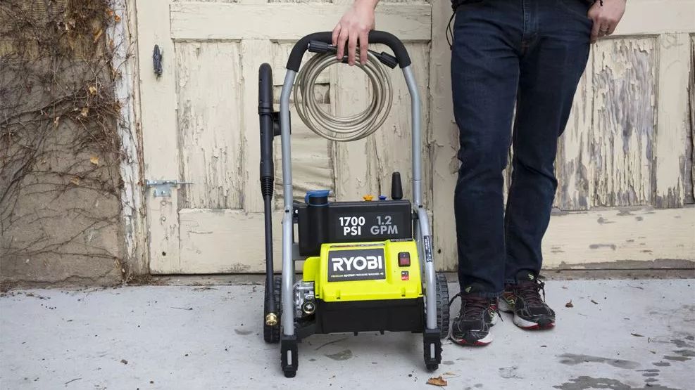 A man standing next to the RYOBI RY14122.