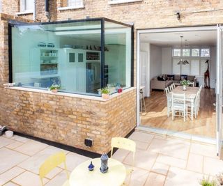 small glass cube and brick extension on terraced brick house