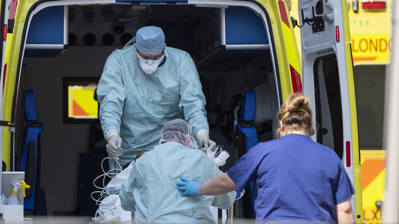 NHS workers in PPE take a patient from an ambulance at St Thomas&amp;#039; Hospital 