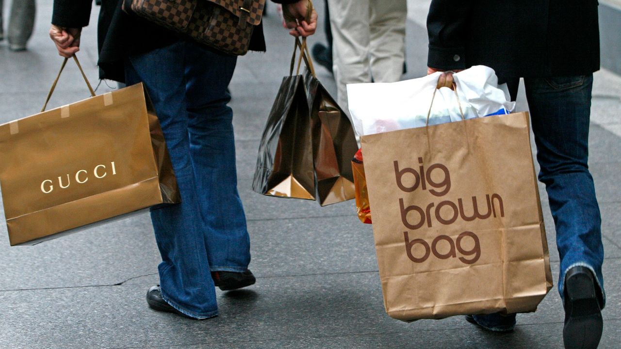 David Benjamin, left, carries shopping bags including a Gucci bag,and Paolo Presta, right, also carries shopping bags, including a &quot;big brown bag&quot; from Bloomingdale&#039;s as the two men stroll down Michigan Avenue, in Chicago, Illinois, Wednesday, December 8, 2006.