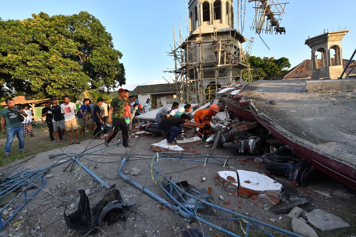 Residents look under the ruins of a mosque in Pemenang, North Lombok, Indonesia, on Aug. 6, 2018, the day after a 6.9/7.0-magnitude earthquake struck the area.