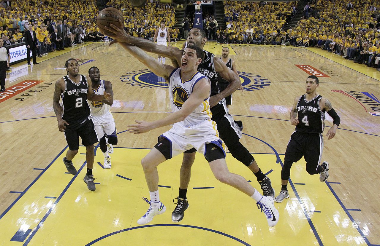 San Antonio Spurs&amp;#039; Tim Duncan blocks a shot by Golden State Warriors&amp;#039; Klay Thompson.