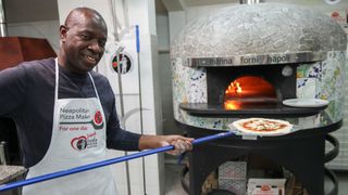 Clive Myrie using a pizza ozen in Naples in Clive Myrie's Italian Road TRip