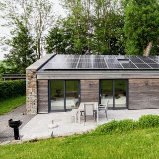 exterior with solar panel green trees and glass door