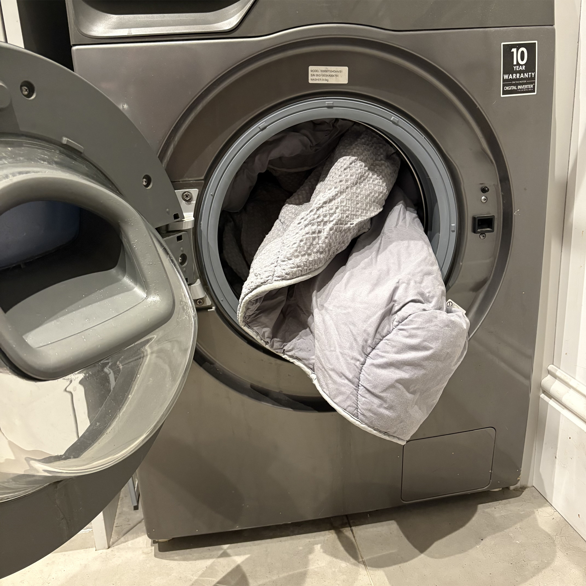 A grey coverless duvet in the washing machine
