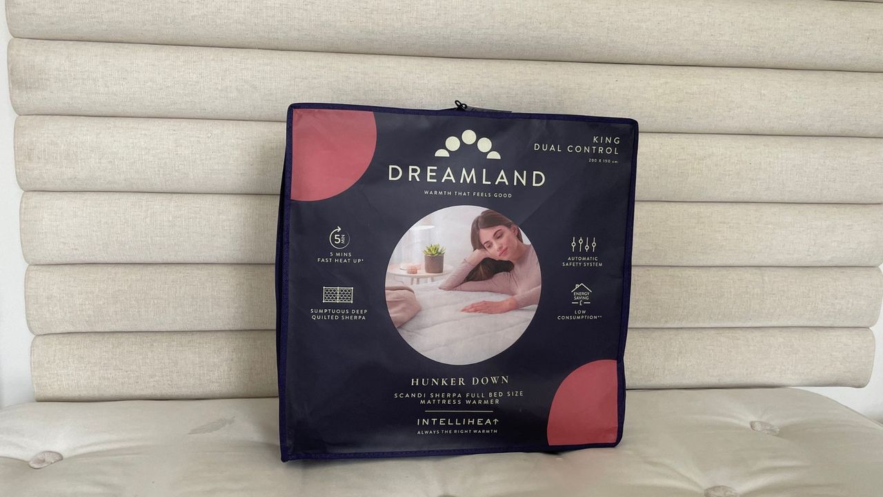 Dreamland Hunker Down Skandi Sherpa Blanket in its bag on a bed