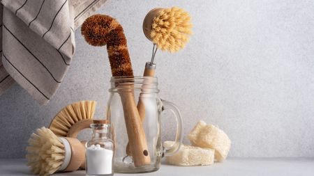 A glass jar filled with natural bamboo cleaning tools