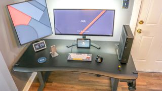 The Vari Curve Electric Standing Desk with dual monitors and a desktop PC