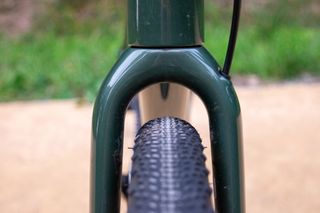 A close up of a bicycle fork with a tyre just fitting within it