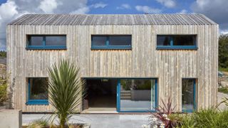 exterior of self build with timber cladding and blue windows