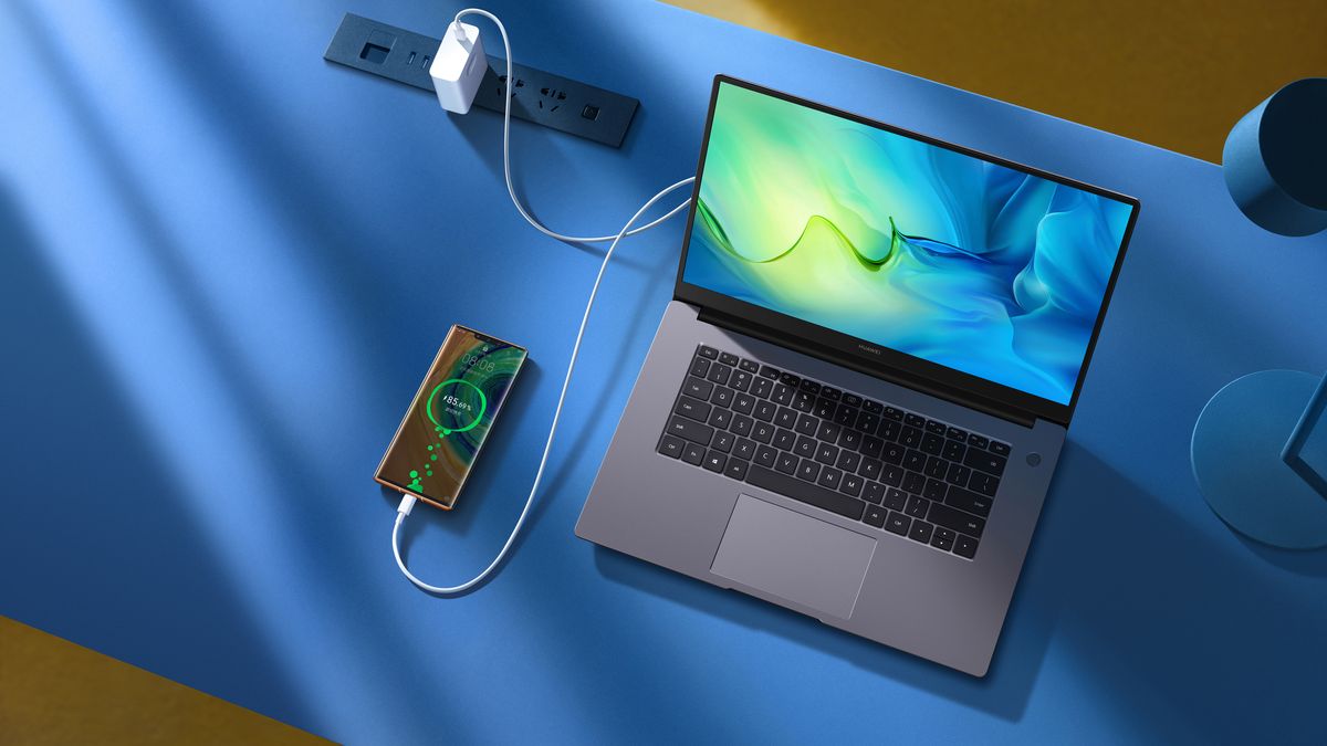 Huawei MateBook D 15 on bed with phone plugged in