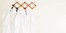 white shirts on hangers - GettyImages-1140091714