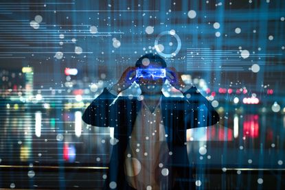 Man wearing VR (virtual reality) goggles looking at a screen of data