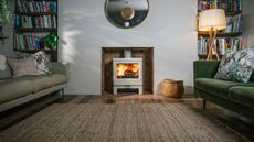 neutral living room with green velvet sofa and cream log burning stove