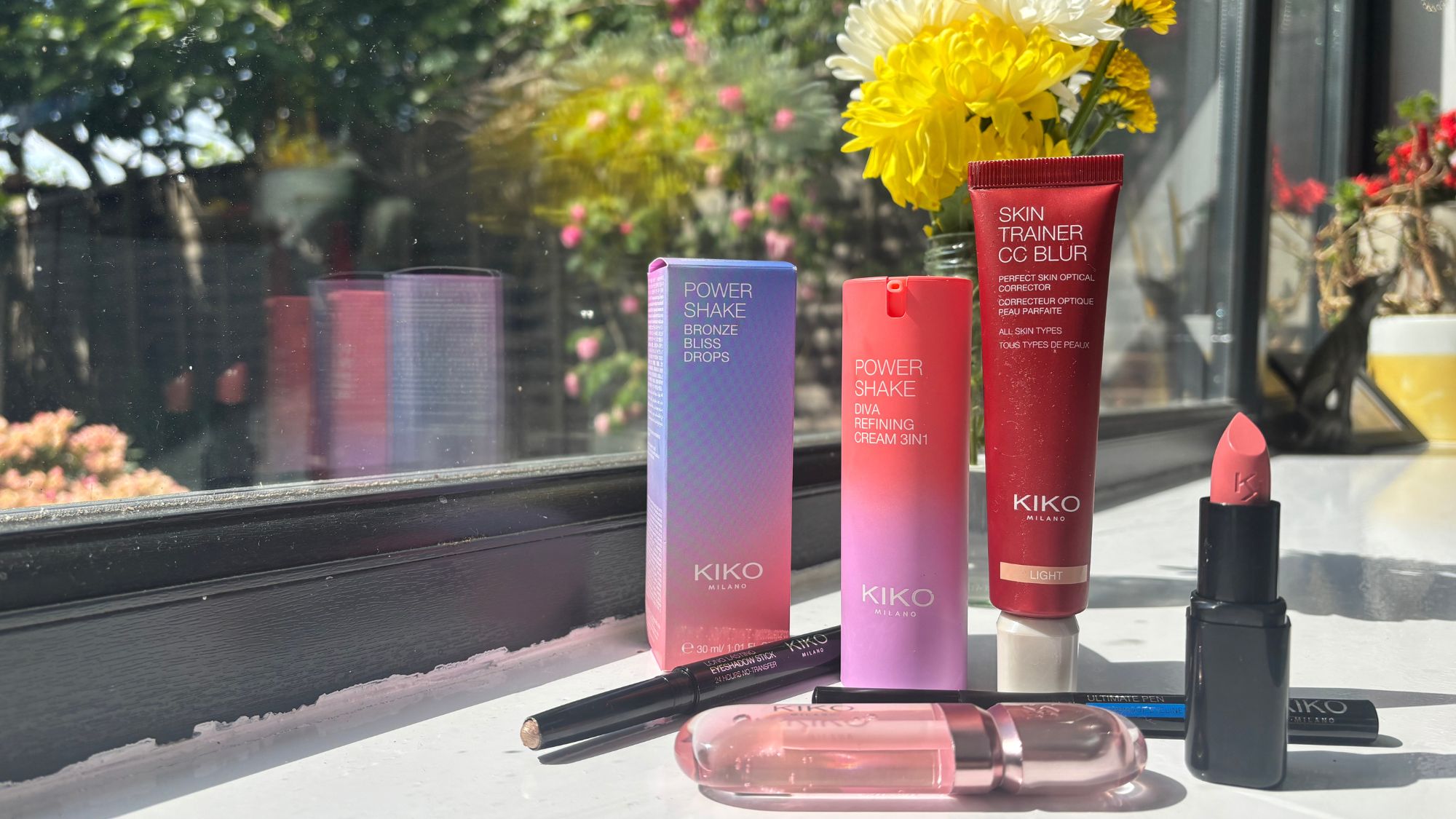 a group of kiko milano products on a sunny window ledge
