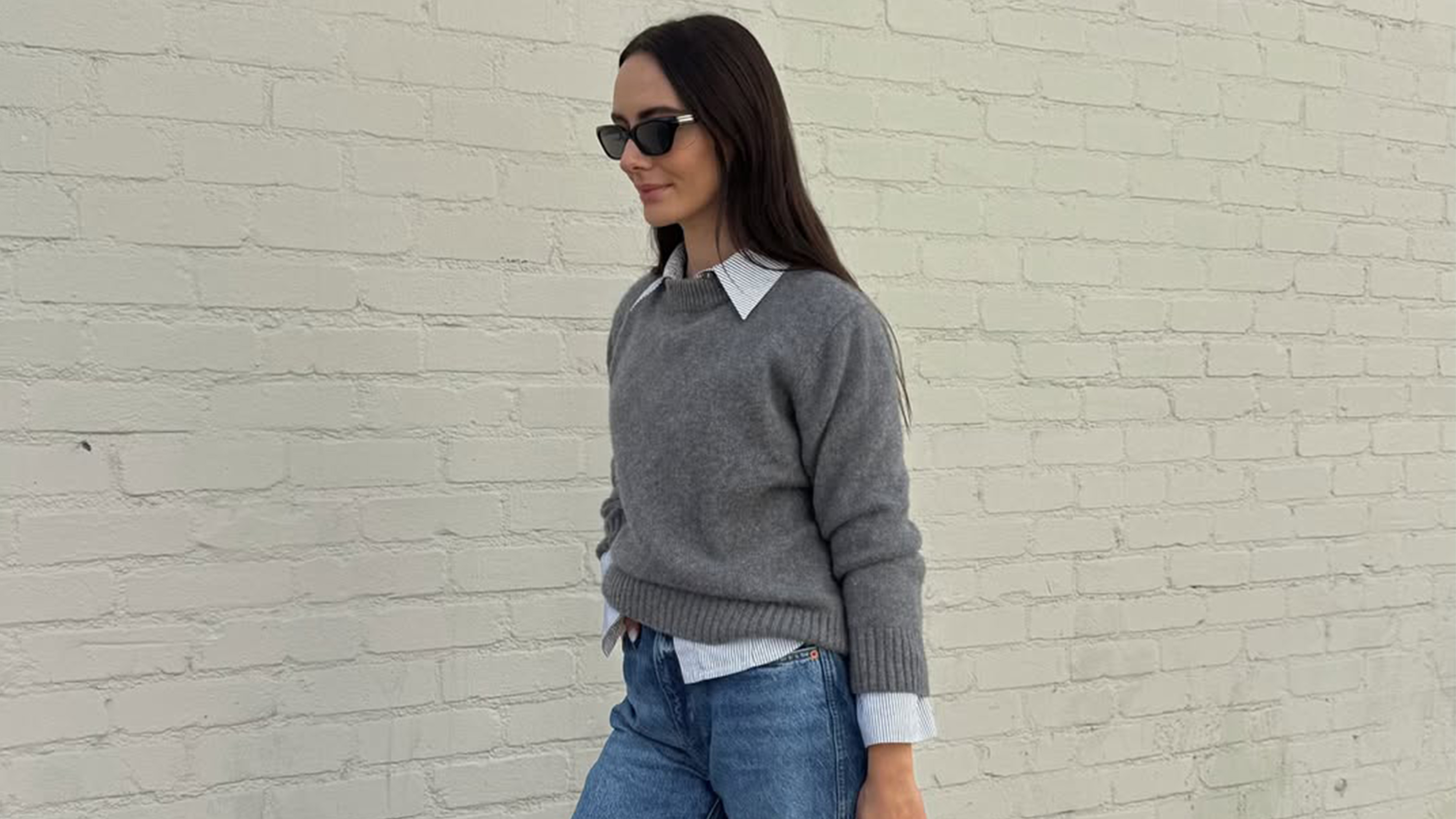 Liv Perez wearing a gray sweater layered over a collared shirt.