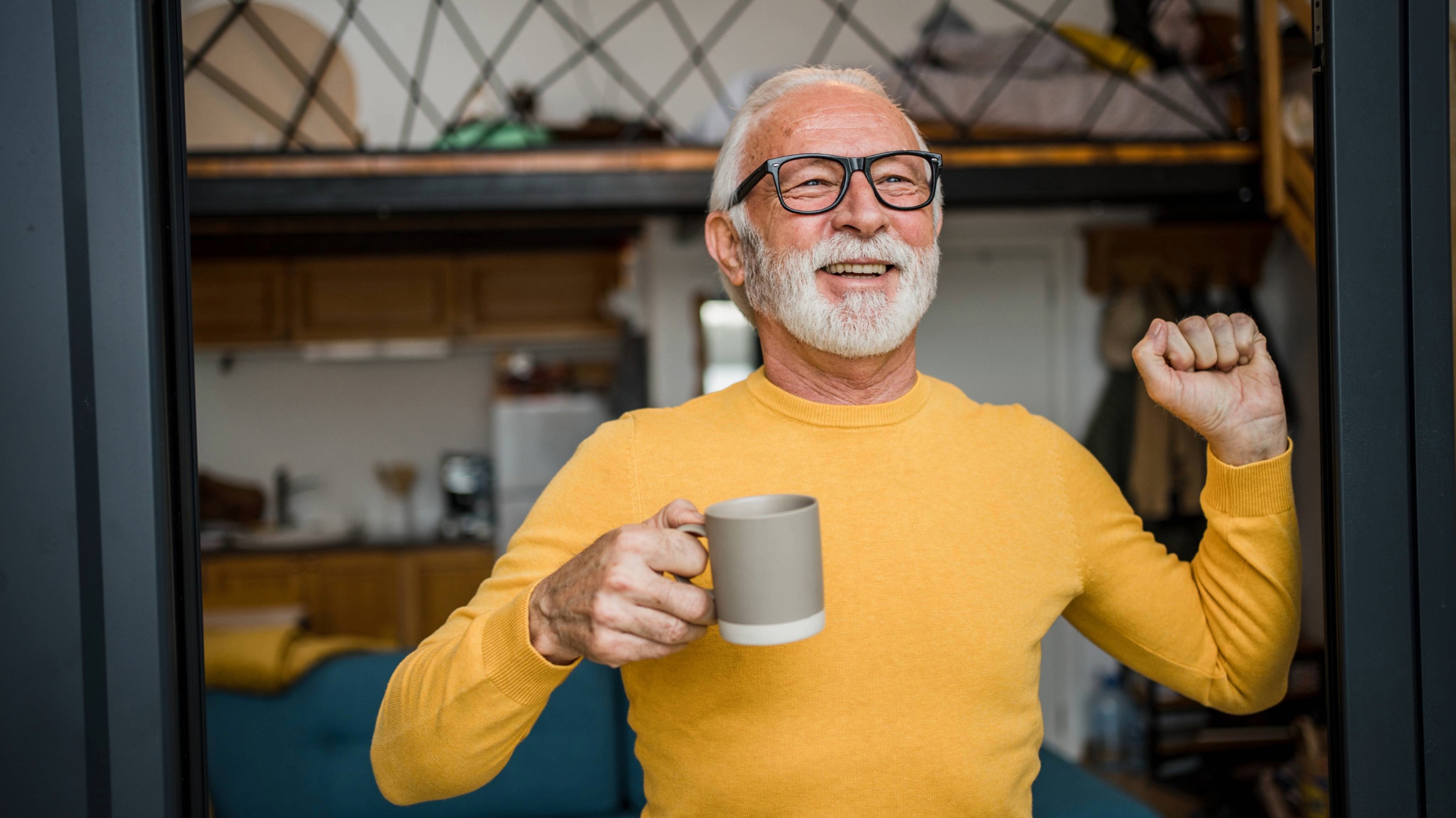 Mature man enjoys morning coffee at the door to his terrace