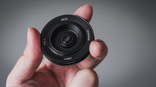 7Artisans 18mm f/6.3 II lens being held in fingertips