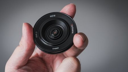 7Artisans 18mm f/6.3 II lens being held in fingertips