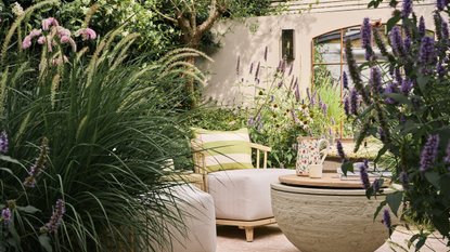 a modern garden with lush planting, purple flowers, and sculptural landscaping