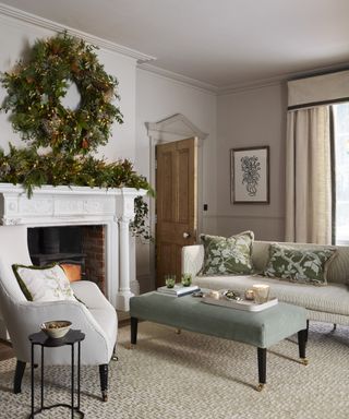 Thanksgiving wreath ideas with large pine wreath and mantel display in neutral, traditional living room