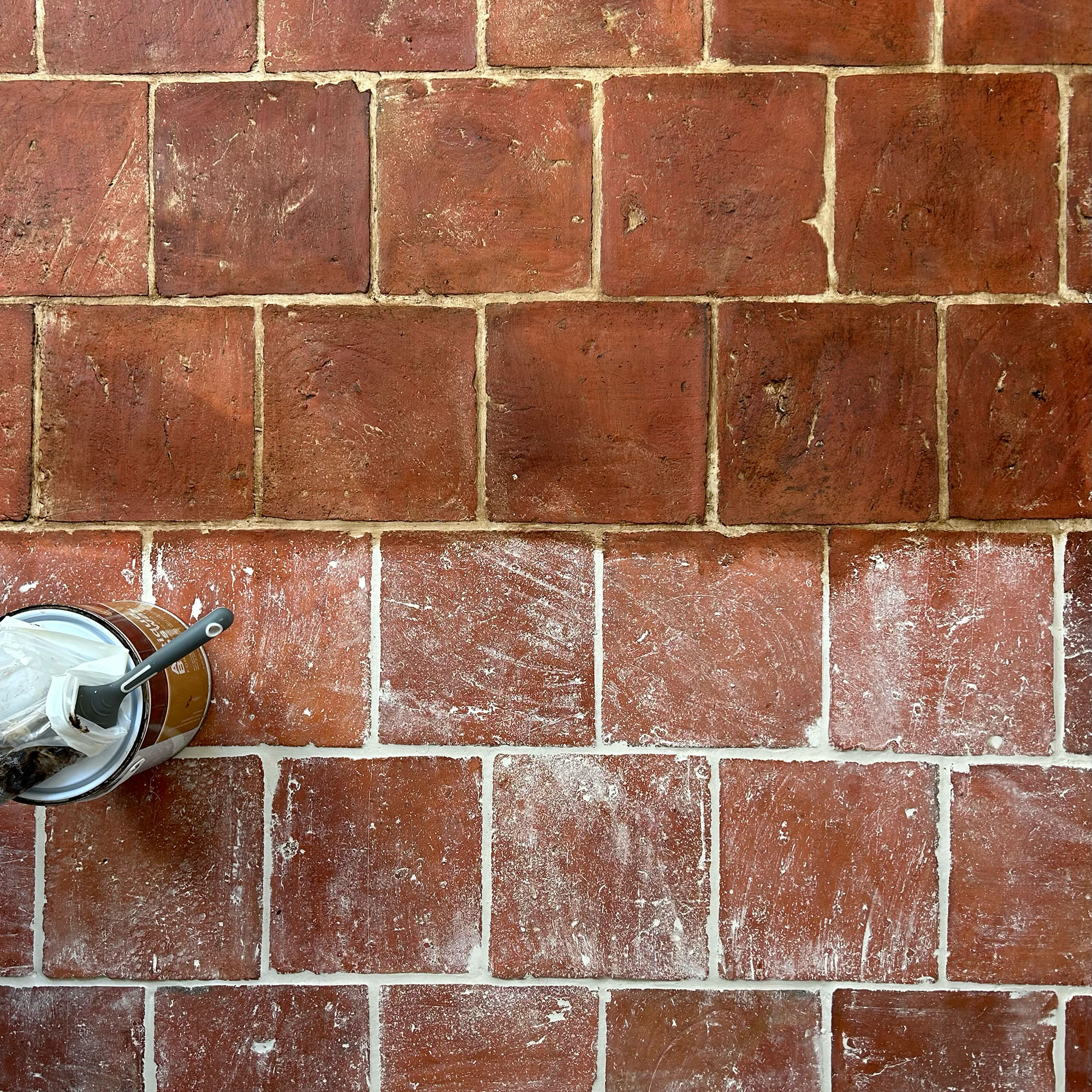 Above view of terracotta tiled floors half treated half untreated