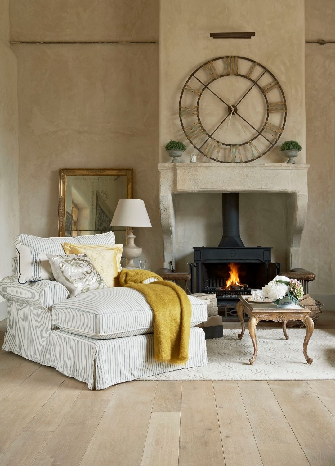picture of cosy spot in living room with armchair and log burning fireplace