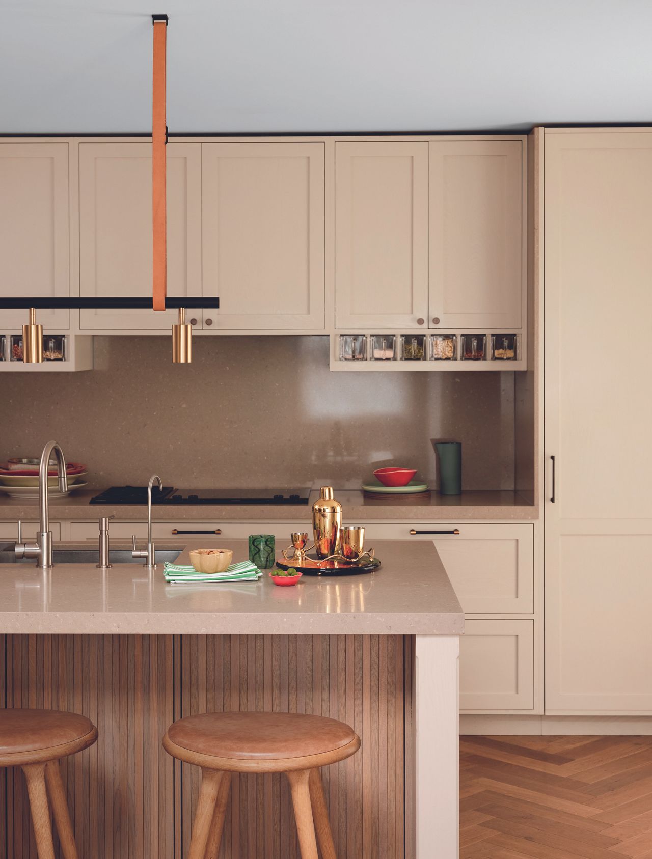 A neutral kitchen with wooden paneling under the island