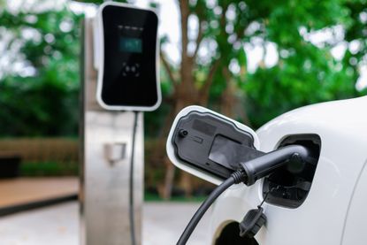 Focus closeup EV car and charger with blur background for progressive concept