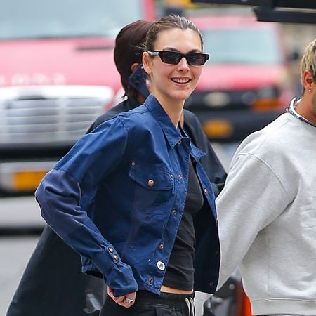 Vittoria Ceretti wearing a navy jacket and black T-shirt with black pull-on pants and butter yellow sneakers in NYC