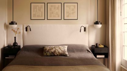 A minimalist bedroom with hanging bedside lights, an extended headboard, black nightstands, reading lights, and a patterned pillow