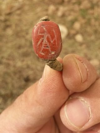 A ring unearthed during the excavation is inlaid with a seal showing an Egyptian warrior holding a shield and sword.