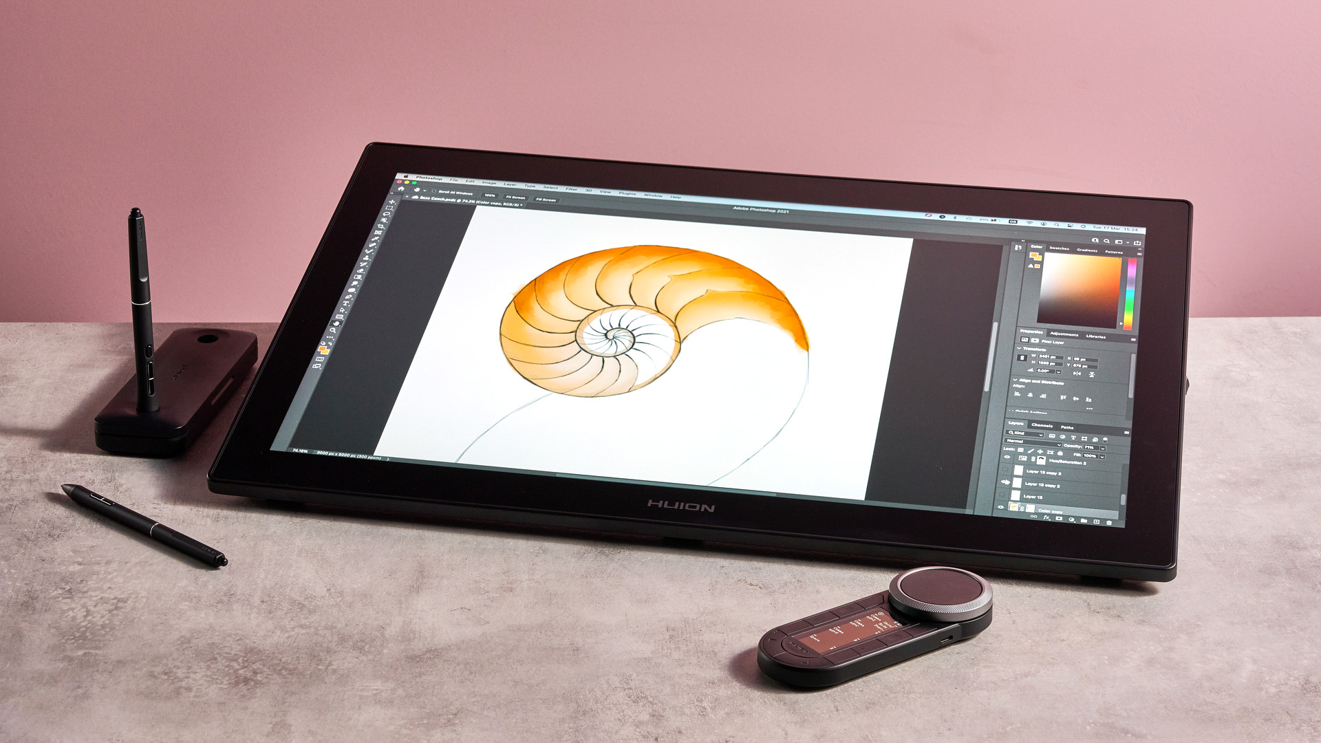 The Huion Kamvas Pro 24 Gen 3 featuring a half-complete sketch of a nautilus shell with bright orange and peach hues, as well as the Keydial Remote, stylus case and styluses.