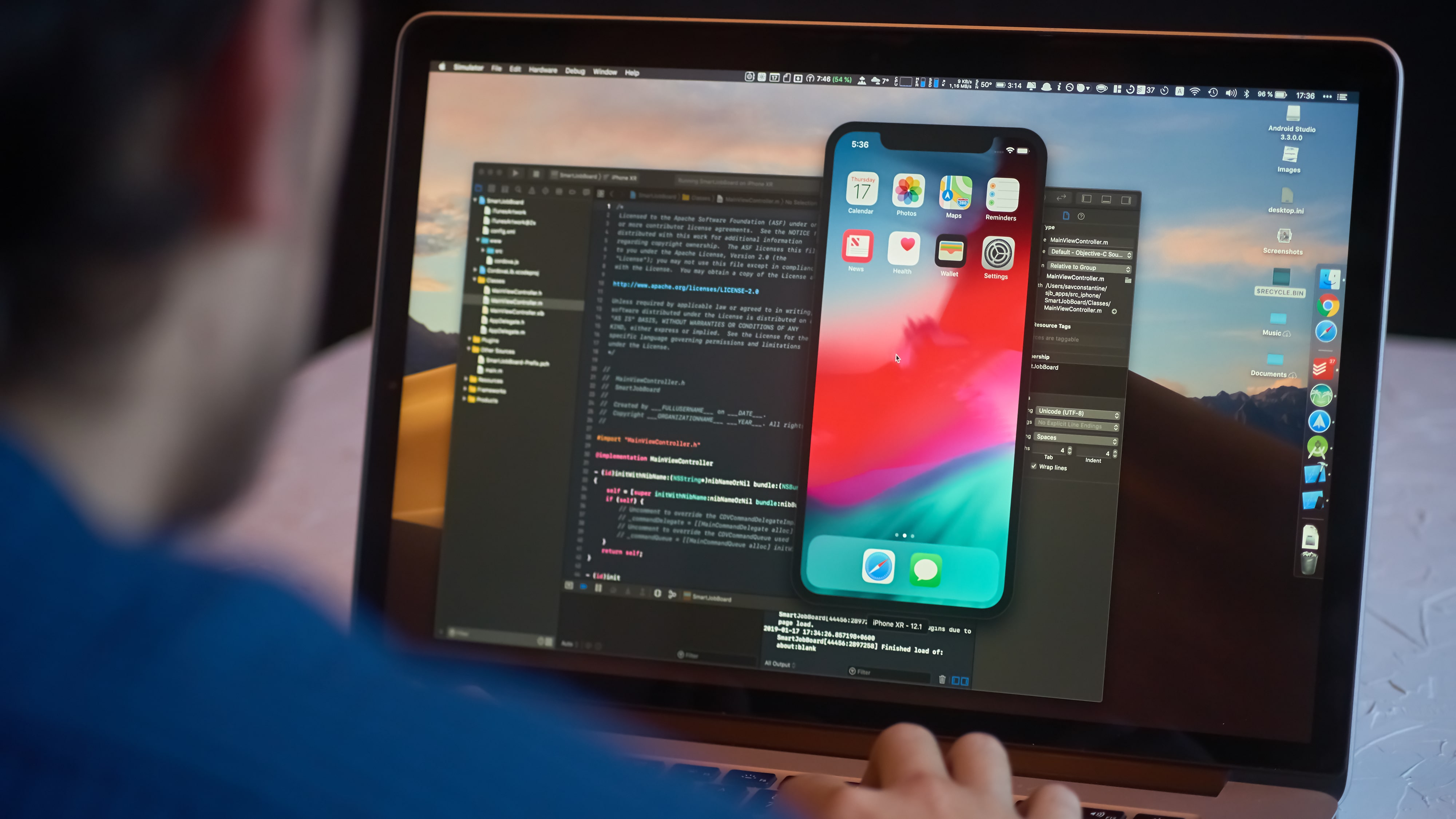 Developer editing iPhone lock screen on laptop
