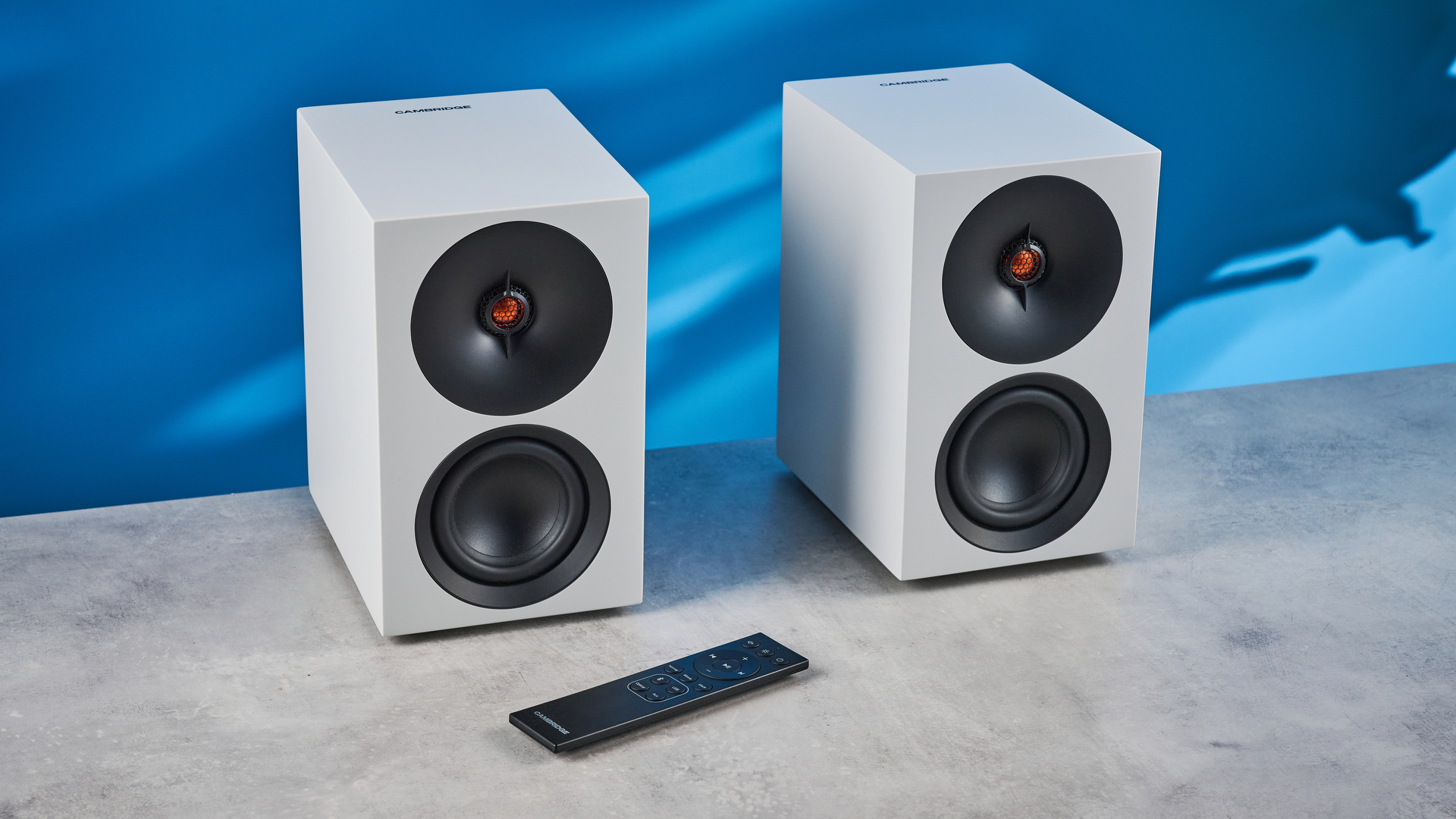 the cambridge audio l/r s bookshelf speakers in white with a 21mm aluminum tweeter and a 3-inch woofer photographed against the blue tom's guide background
