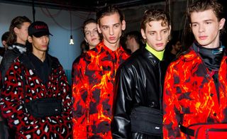 A line of male models in red/black clothing